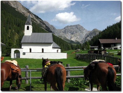 Kirche S-charl und Pferde bereit für den touristischen Ausritt